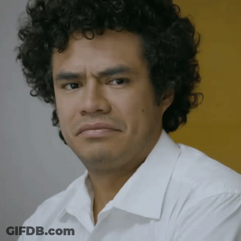 Curly Haired Man Making Serious Face In White Shirt GIF