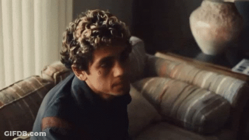 Curly Haired Man On Couch In Front Of Mirror GIF