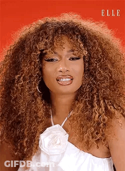 Curly Haired Woman In White Dress And White Flower Necklace GIF
