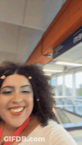 Curly Haired Woman Smiling At E3 Sign GIF