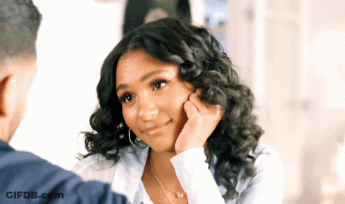 Curly-Haired Woman Touching Face Man Looks On GIF