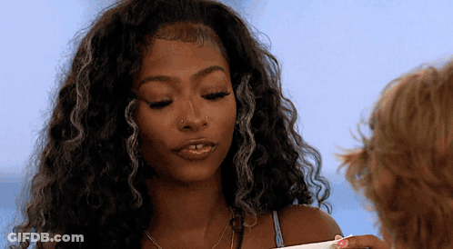 Curly-Haired Woman With Nose Ring Looking Down GIF