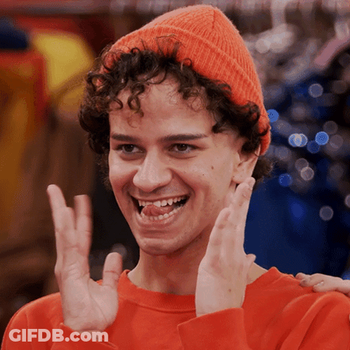 Curly Haired Young Man In Orange Hat And Sweater GIF