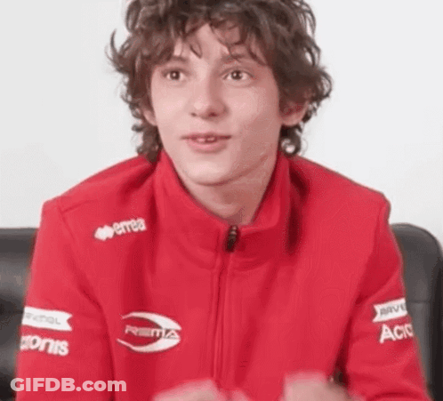 Curly Haired Young Man In Red Jacket With Sponsors GIF
