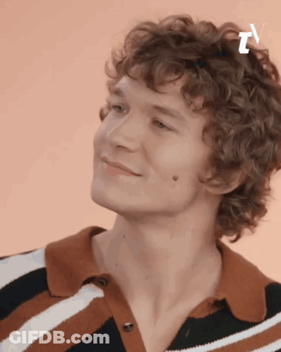 Curly Haired Young Man Smiling In Striped Shirt GIF