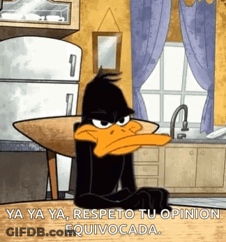 Daffy Duck Is Sitting At A Table In A Kitchen With A Refrigerator In The Background . GIF
