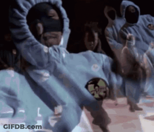 Dancing People In Hooded Sweatshirts And Masks In Dark Room GIF