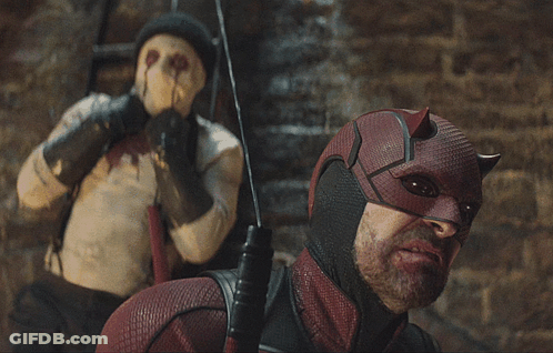 Daredevil Costume Man Next To Masked Man GIF