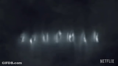 Dark Background With Sandman In White Letters GIF