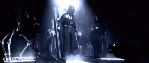 Darth Vader And Emperor Palpatine Standing Next To Each Other In A Dark Room GIF