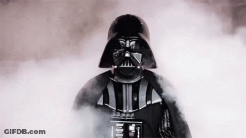 Darth Vader From Star Wars Is Standing In A Cloud Of Smoke And Looking At The Camera . GIF