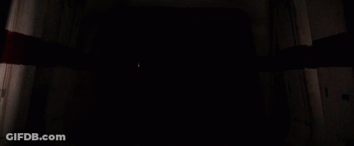 Darth Vader Holding A Red Light Saber In A Dark Room GIF