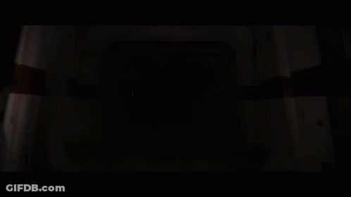 Darth Vader Holding A Red Lightsaber In A Dark Room GIF