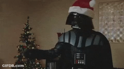 Darth Vader Is Holding A Lightsaber In Front Of A Christmas Tree . GIF