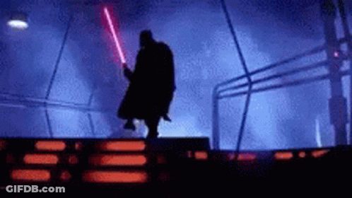 Darth Vader Is Holding A Red Lightsaber In A Dark Room GIF