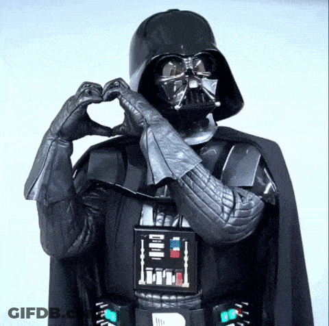 Darth Vader Is Making A Heart Shape With His Hands In A Star Wars Costume . GIF