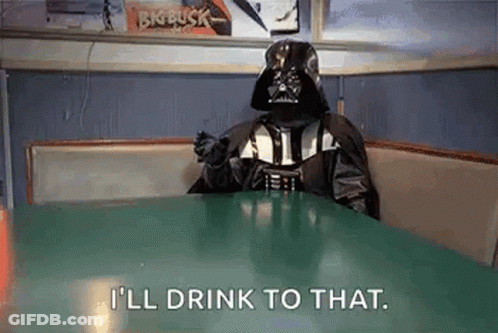 Darth Vader Is Sitting At A Table With A Drink In His Hand . GIF