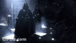 Darth Vader Is Standing In A Dark Room With Two People . GIF