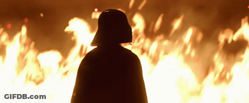 Darth Vader Is Standing In Front Of A Fire GIF
