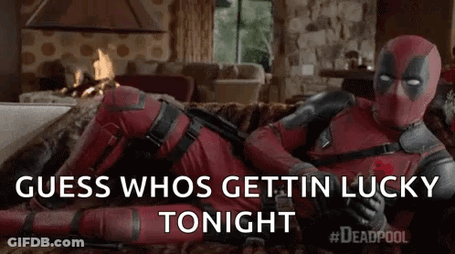 Deadpool Is Laying On A Couch In A Living Room Holding A Rose . GIF