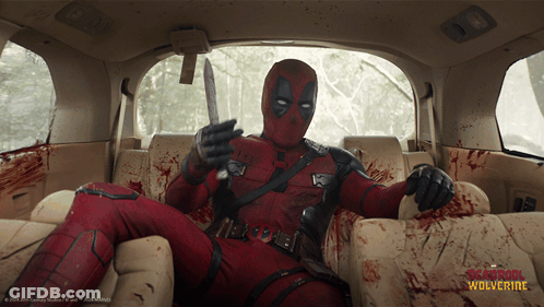 Deadpool Is Sitting In The Back Seat Of A Car With A Knife In His Hand GIF