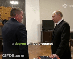Decree Displayed On Screen Between Two Men GIF