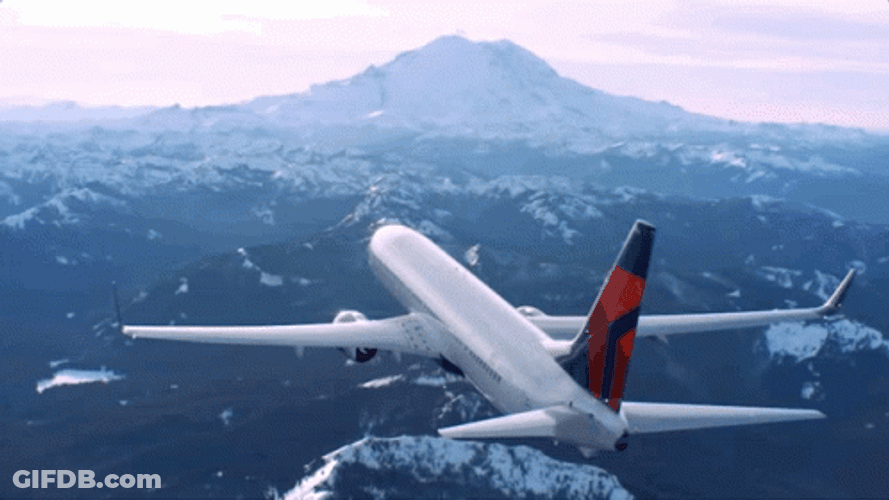 Delta Airline Flying Above Snowy Mountains GIF