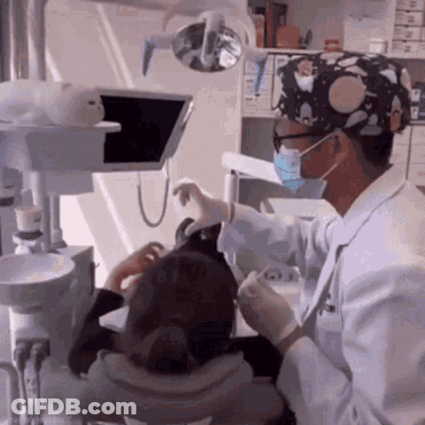 Dentist Examining Child's Teeth With Mask GIF