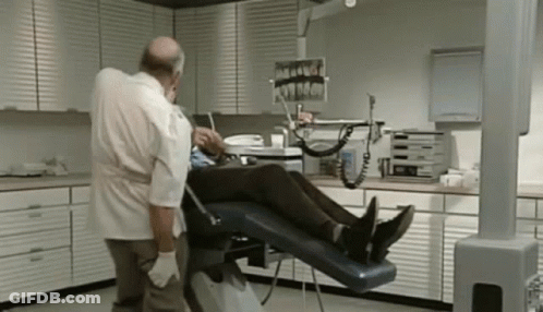 Dentist Examining Patient's Teeth In Dental Chair GIF