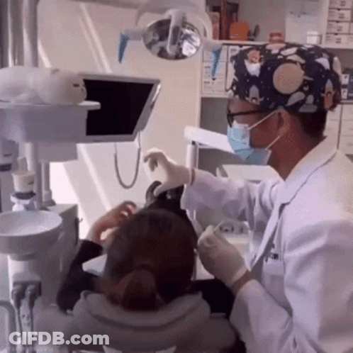 Dentist In Mask And Gloves Examining Patient's Teeth GIF