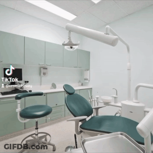 Dentist's Office With Green Chair And Computer On Counter GIF