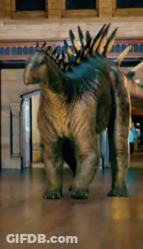 Dinosaur On Wooden Floor Near Brick Building GIF