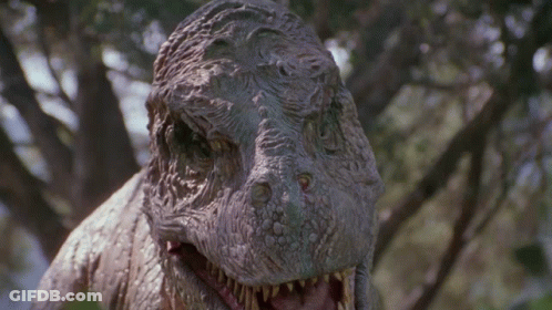 Dinosaur Statue With Open Mouth Looking At Camera GIF