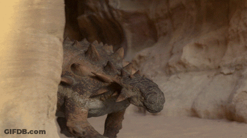 Dinosaur With Spikes Standing In Cave GIF