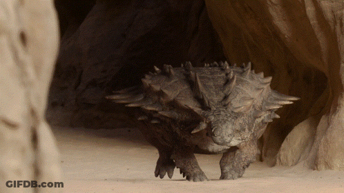 Dinosaur With Spikes Walking On Sand GIF