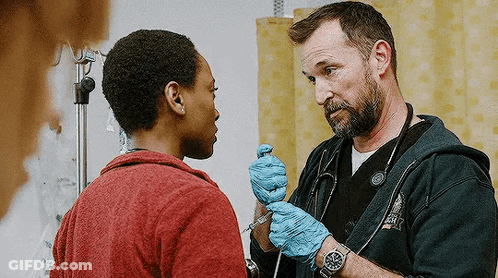 Doctor Talking To Patient Holding Syringe In Emergency Room GIF