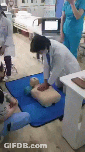 Doctors Practicing CPR On Mannequin In Hospital GIF