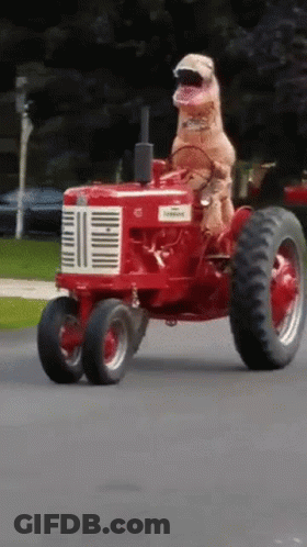 Dog In T-Rex Costume Driving Red Farmall Tractor GIF