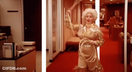 Doll In Pink Dress Sitting On Toilet Paper Bringing Style To The Bathroom GIF
