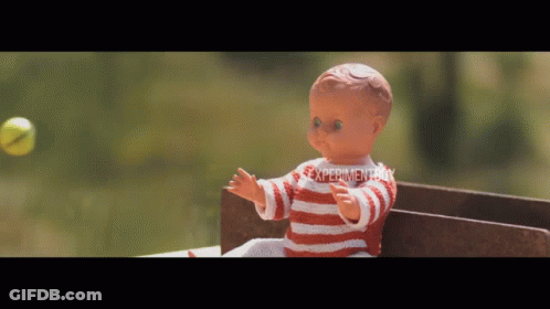 Doll In Red And White Striped Shirt Playing With Tennis Ball In Front Of Experiment Sign GIF