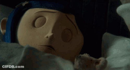 Doll Laying On Bed With Blue Nail Polish On Nose GIF