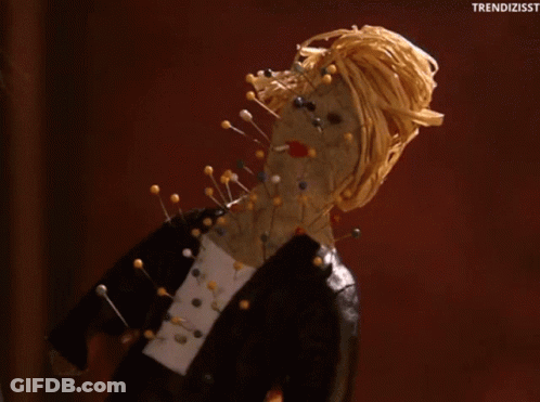Doll With Pins On Face And Neck GIF