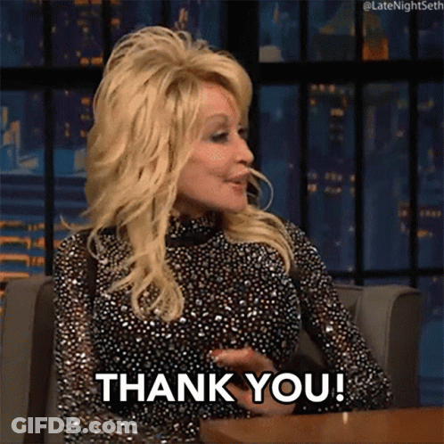 Dolly Parton Is Sitting At A Table And Saying " Thank You " GIF