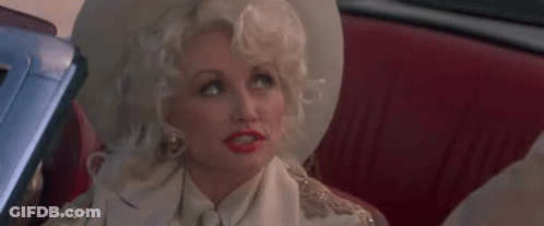 Dolly Parton Is Sitting In The Back Seat Of A Car Wearing A White Hat And A White Shirt . GIF