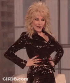 Dolly Parton Is Wearing A Black Sequined Jacket And A Black Dress . GIF