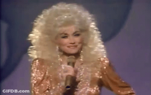 Dolly Parton Smiling At Microphone On Stage GIF