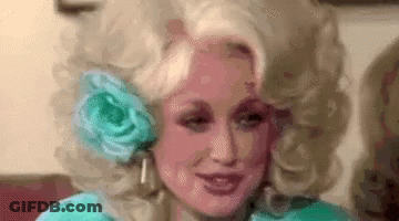 Dolly Parton Wearing Wig With Flower In Ear GIF