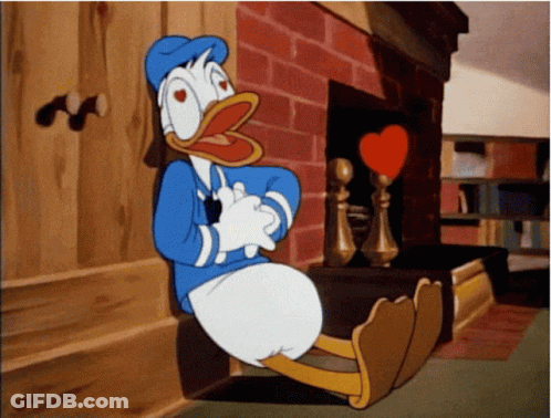 Donald Duck Is Sitting In Front Of A Fireplace With A Heart In His Mouth GIF