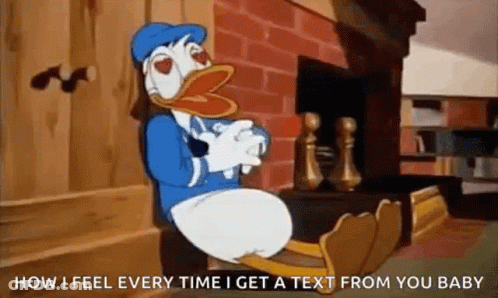 Donald Duck Sitting On Bench By Fireplace With Feet Up GIF