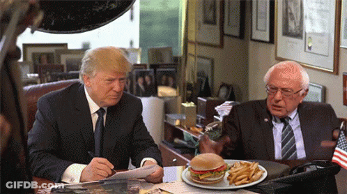 Donald Trump And Bernie Sanders Sitting At Desk With Plate Of Food GIF